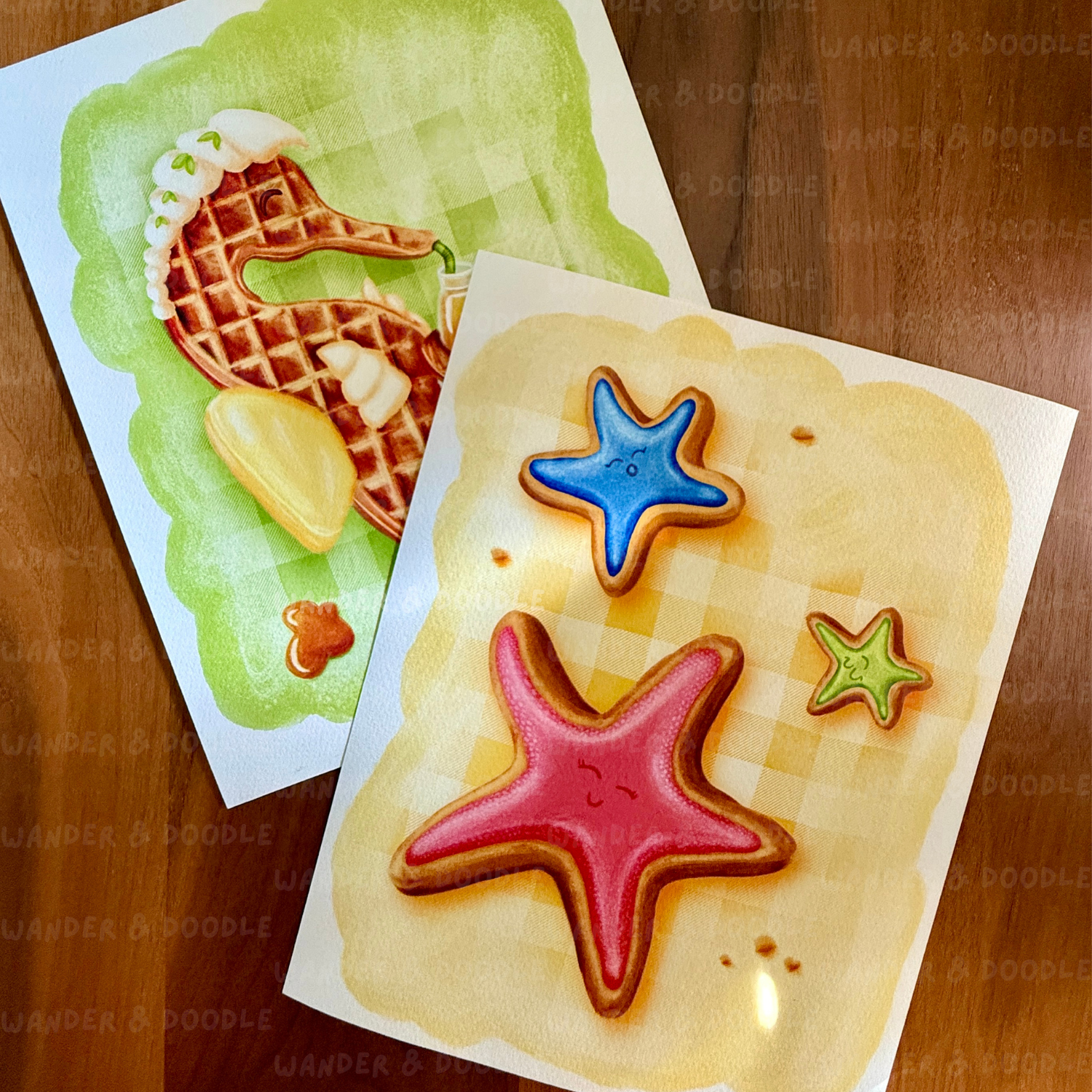 Two cards with starfish sugar cookie illustration and waffle designs on a wooden surface.